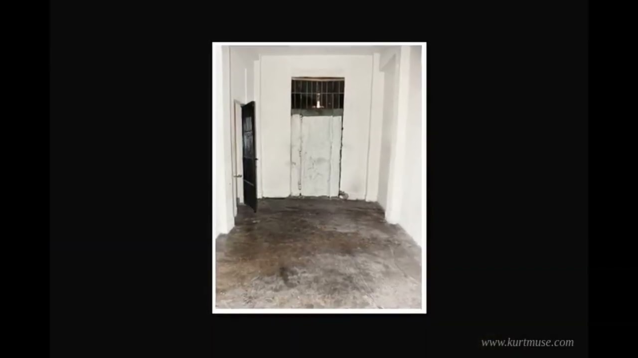 Corridor and open steel door of a cell inside Cárcel Modelo